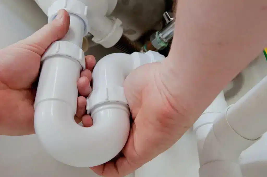 person wrapping their hands around white pipe